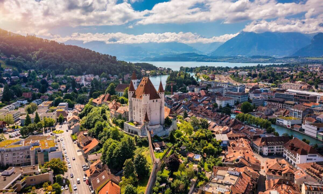 Das Schloss Thun vor einer beeindruckenden Bergkulisse Das Schloss Thun vor einer beeindruckenden Bergkulisse